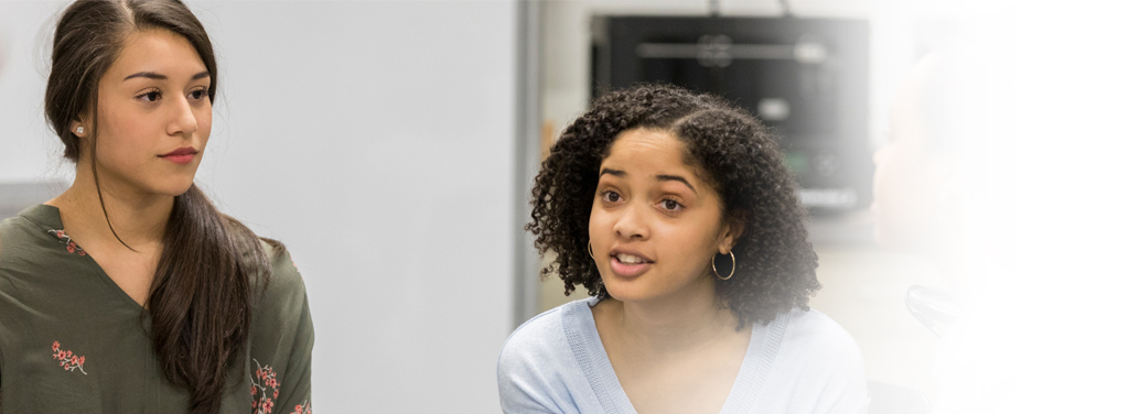 Girl talking with a group of people.