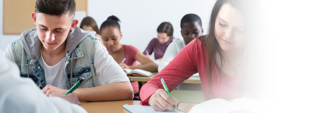 Young multiethnic students listening a teacher in the classroom.